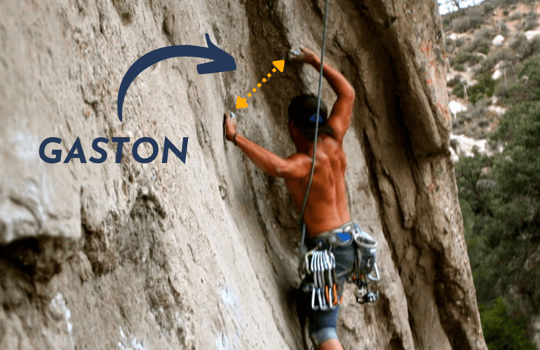 A man doing a Gaston while rock climbing